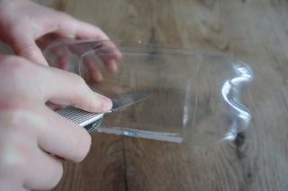 Mit dem Taschenmesser schneidet Ihr zwei große Fenster in die Plastikflasche. Foto: (c) Kinderoutdoor.de